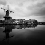 grayscale photo of building near body of water