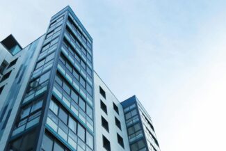 Low-angle view of a modern glass skyscraper against a clear sky in Poole, UK.