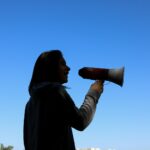 man in black hoodie drinking from a bottle