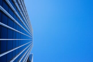 low-angle photography of curtain glass building under blue sky
