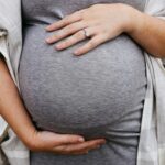 a pregnant woman holding her belly in her hands