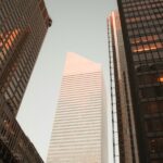 low-angle photography of gray high-rise building between two curtain wall high-rise buildings during daytime